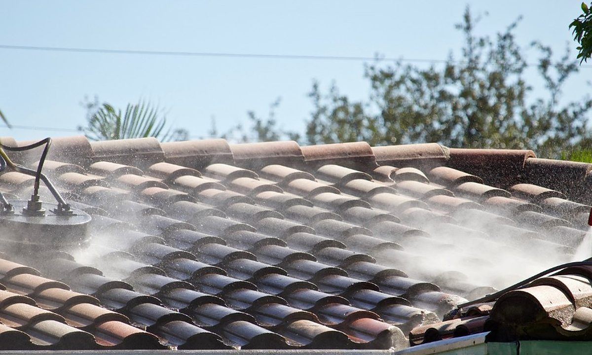 Limpieza del musgo de un tejado de teja con agua a presión