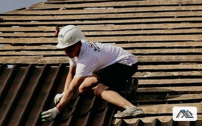 Operario con casco trabajando sobre una cubierta de placa ondulada
