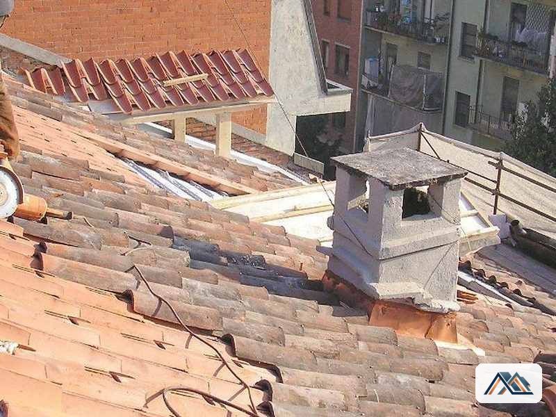 Reparación del encuentro de una chimenea de piedra con el faldón en una casa de Melide