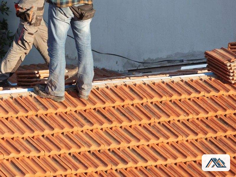 Colocación de teja nueva durante un retejado de cubierta en Lugo